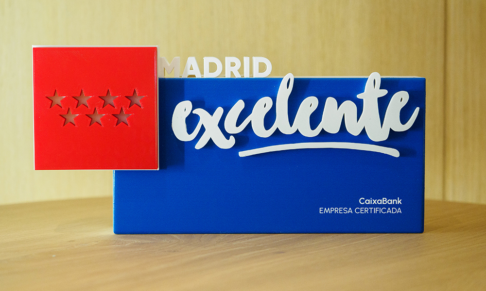 Figura conmemorativa de Madrid Excelente con la inscripción CaixaBank, empresa certificada.