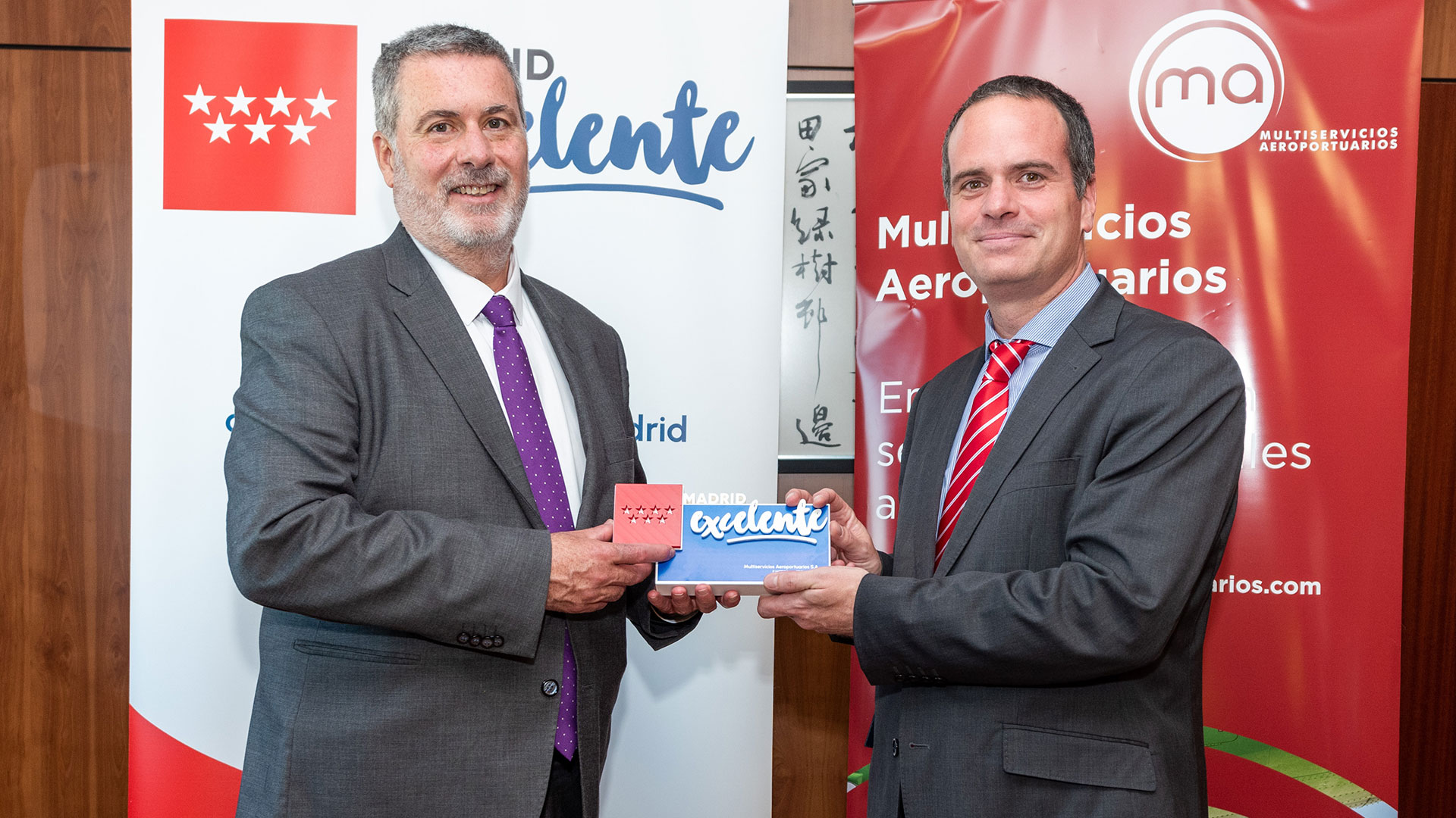 A la izquierda, Rafael Barberá, director general de Madrid Excelente, hace entrega de la figura conmemorativa a Iker Azcua, a la derecha, director general de Multiservicios Aeroportuarios.